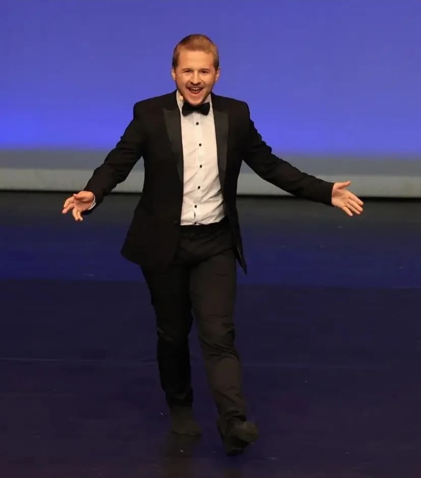 Yannick Reuß im Smoking beim Tanzauftritt auf der Bühne